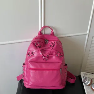 Stylischer pinkfarbener Kunstlederrucksack mit Pentagramm-Gurt und Nietendetails.