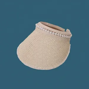 Close-up of a stylish cream straw sun visor with elegant pearl trim decoration