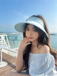 Visière pare-soleil bleu clair pour femme dans un cadre de vacances en bord de mer