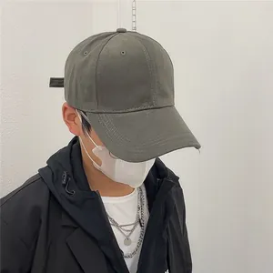 Vue détaillée d'une casquette de baseball grise vintage portée par un mannequin en veste noire
