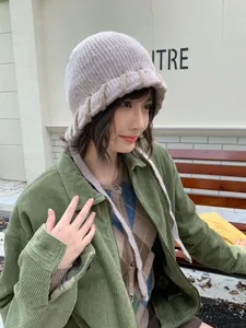 Weibliches Model trägt eine gemütliche, beige farbblock-gestrickte Balaclava-Mütze.