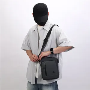 Close-up of a model wearing a grey fashion messenger bag with adjustable shoulder strap