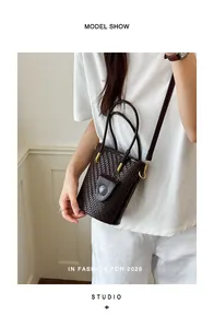 Detail view of a brown woven bucket bag for women, chic and versatile crossbody style