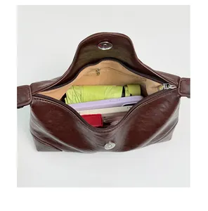 Innenansicht der braunen Schultertasche mit Darstellung der Kapazität für Alltagsgegenstände.