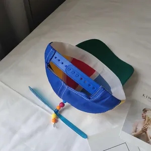 Detailed view of the rotating blue propeller and beads on a color-blocked kid's cap