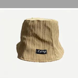 Macro view of the khaki pleated fabric texture on a stylish women's sun bucket hat