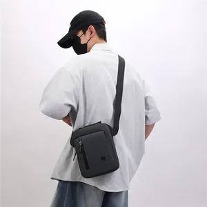 Casual grey crossbody messenger bag shown on a model for a stylish streetwear look