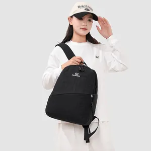 Model wearing a minimalist large capacity black Japanese style casual sports backpack