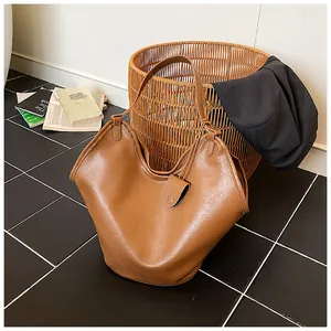 Close-up detail of a large brown slouchy hobo shoulder bag in a stylish lifestyle setting