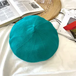 Top-down view of a turquoise knitted beret showcasing detailed weave texture