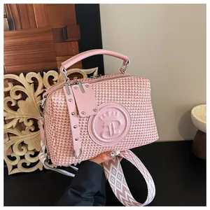Detaillierte Nahaufnahme der rosa strukturierten Handtasche mit breitem gemustertem Gurt