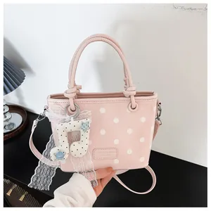 Pink polka dot handbag with a stylish musical note charm and lace detail for women