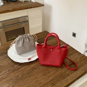 Vue détaillée d'un mini sac seau en cuir rouge avec pochette intérieure rayée