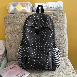 Detailed view of black backpack with white star patterns and striped side pockets.