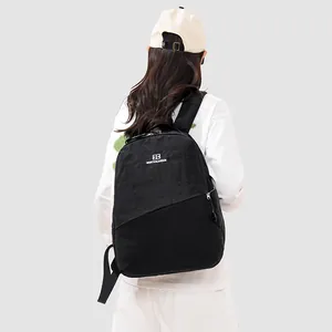 Back view of a large-capacity black sports backpack worn by a model in casual wear