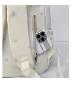 Close-up detail of the secure back zipper pocket on this white floral student backpack