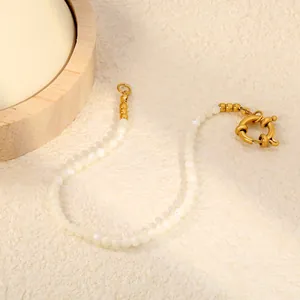 Vue détaillée d'un bracelet en perles blanches délicat avec un fermoir en acier doré