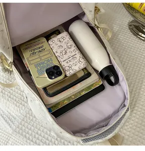 Detail view of large capacity cream backpack showing spacious interior storage space