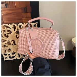Detailaufnahme der rosa gewebten Handtasche mit luxuriösem Kronen-Logo und Trageriemen.