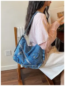 Vue latérale du sac bandoulière en denim vintage avec détails zippés style motard