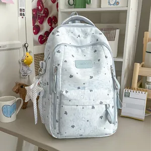 Light blue Korean style star backpack with maple leaf pattern in cozy desk setting.