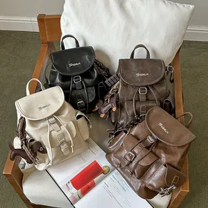 Detailed view of vintage style faux leather backpacks in multiple colors on a cozy chair