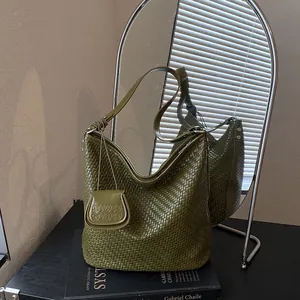 Close-up of green woven bucket bag with embossed small pouch detail