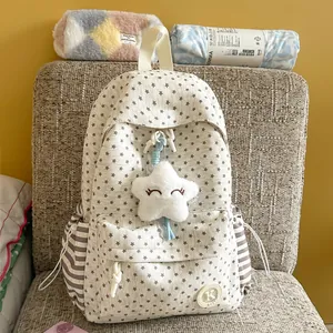 Detail of a Korean style cream backpack with star patterns and a plush star keychain