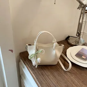 Retro off-white bucket bag with unique knot handles and elegant pearl tulip charm