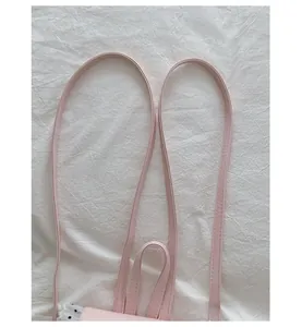 Detail shot of pink backpack straps and high-quality stitching on white fabric.