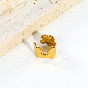 Λεπτομέρεια από χρυσό σκουλαρίκι ear cuff με σχέδιο λουλούδι από ανοξείδωτο ατσάλι.
