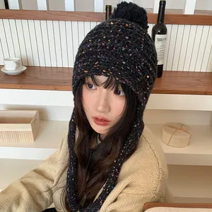 Cozy black knitted pom-pom beanie featuring colorful speckles and protective warm earflaps