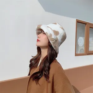 Close-up profile of a model wearing a plush cow-print bucket hat in winter