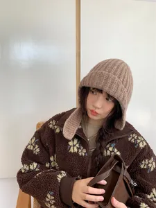 Asiatisches Modell mit einer gemütlichen braunen Strickmütze und einer Fleecejacke