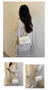 Detailweergave van een witte gewatteerde kettingtas met een retro minimalistische look