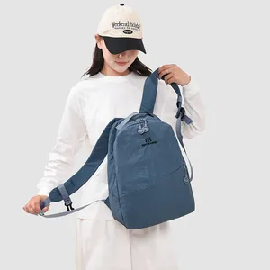 Close-up of a blue Japanese-style leisure backpack worn by a model in a studio setting.