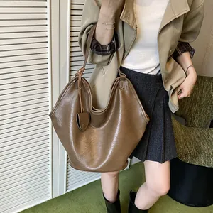 Stylish large brown hobo bag in lazy style shown on model with vintage leather texture