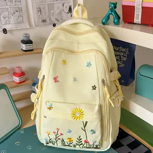 Zaino giallo per studenti con ricami floreali colorati in un ambiente accogliente