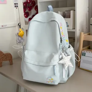 Detailopname van een lichtblauwe studentenrugzak met borduursel en sterhanger.