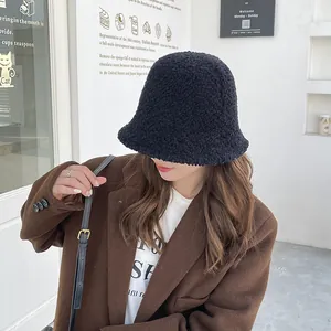 Warm black faux fur bucket hat shown on model for a stylish winter accessory look.