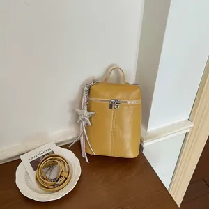 Vista dettagliata della borsa a tracolla gialla minimalista con ciondolo a stella marina