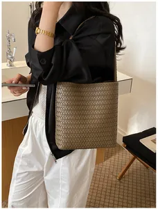 Detalle de mujer con un bolso de hombro trenzado marrón para un estilo de verano