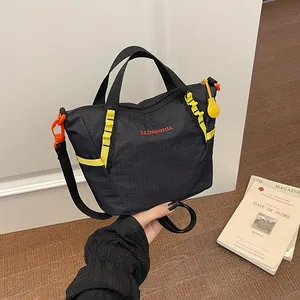 Close-up of a black nylon fitness bag with yellow straps and detailed grid texture