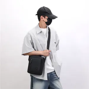 Model wearing a stylish black crossbody messenger bag in a minimalist casual outfit