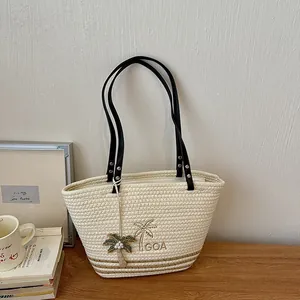 Detailansicht der gewebten Stroh-Tote-Bag mit Palmstickerei und schwarzen Griffen