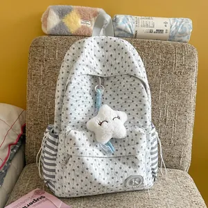 Detailed view of a grey star-patterned school backpack with a plush star pendant