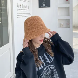 Stylish brown sherpa bucket hat worn by a model in a casual outdoor street setting