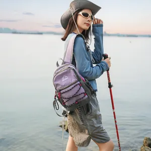 Wanderszene im Freien mit einer Frau, die den leichten lila Rucksack am See trägt.