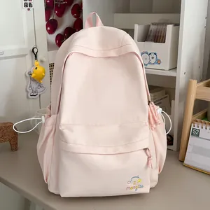 Detailopname van een lichtroze studentenrugzak met schattig geborduurd patroon