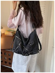 Vue arrière d'un sac à dos rétro en jean délavé noir style motard pour femmes en plein air.